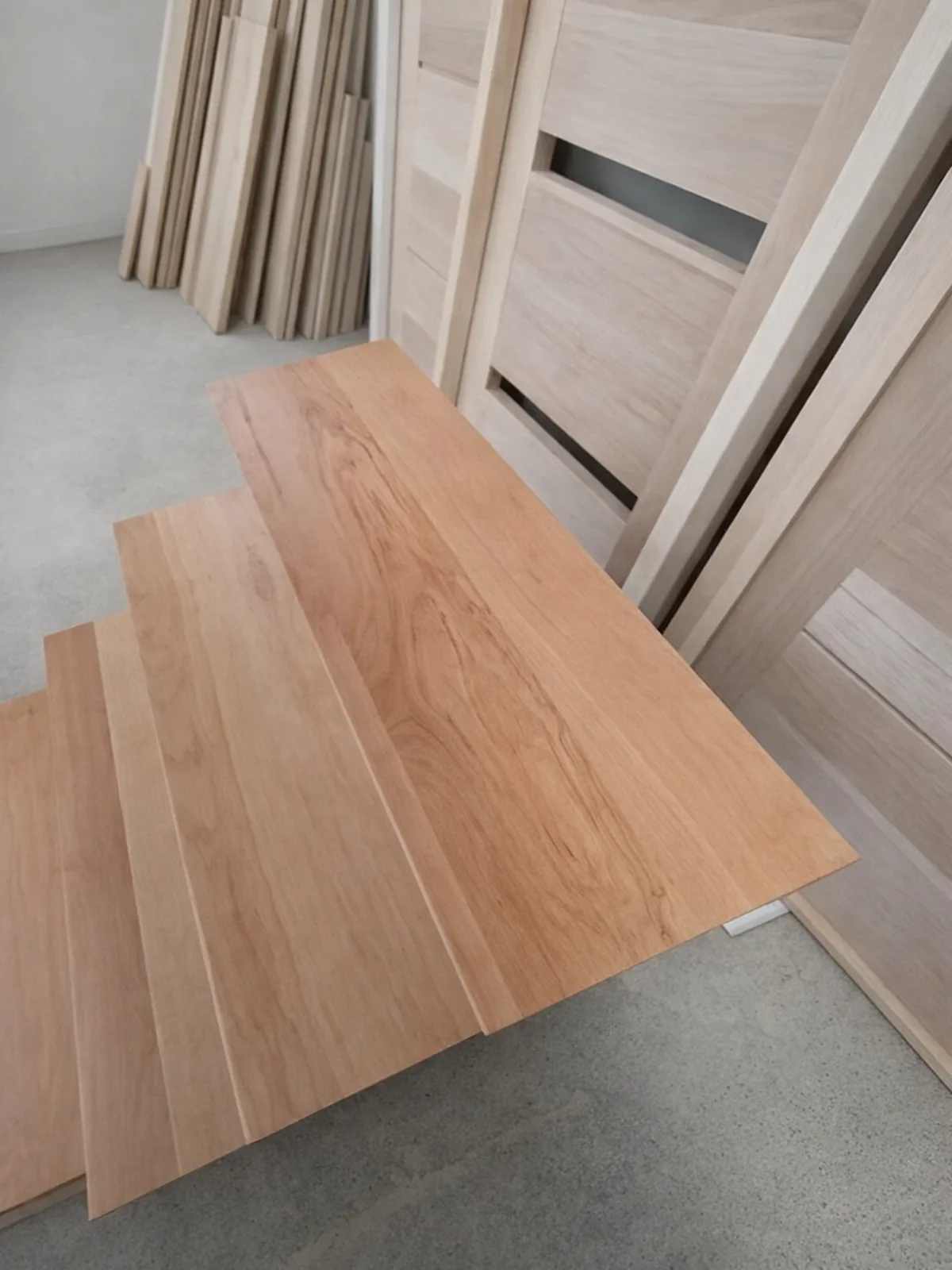 Peldaños de madera clara a medida recién cepillados en el taller
