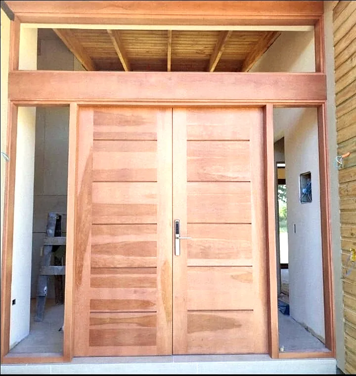 Puerta doble de madera con montante y dintel en la entrada