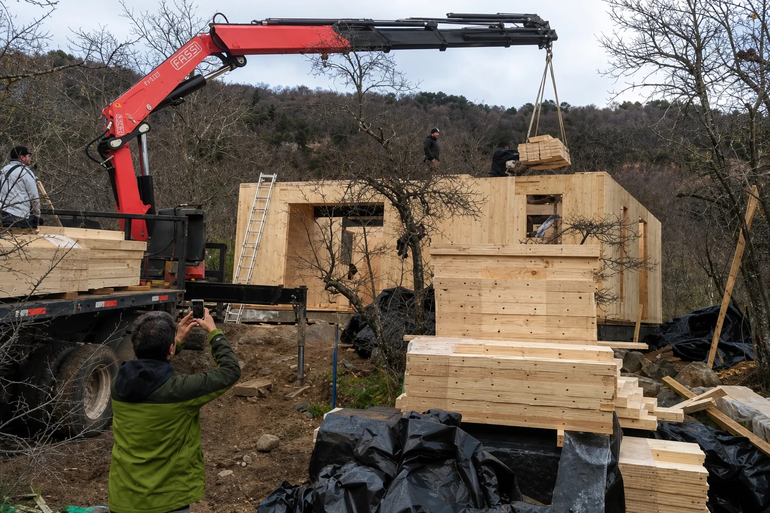 Montaje de una vivienda compacta de madera en terreno: grúa posicionando paneles sobre la estructura